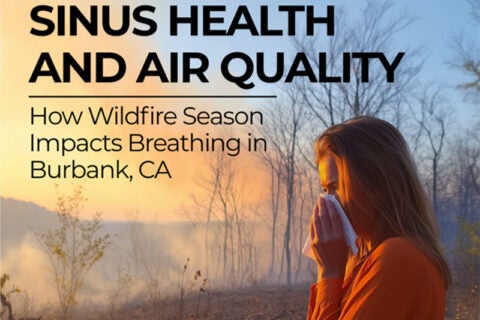 Woman in a forest during wildfire season, using a tissue to cover her nose