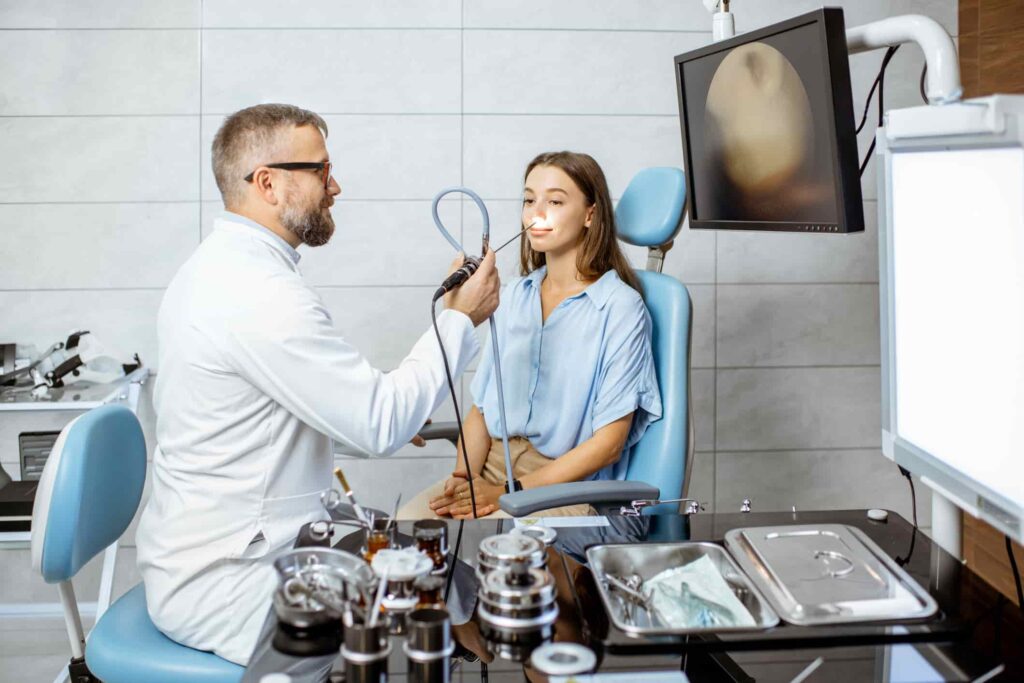 In a doctor's office, a man checks a woman's eye, part of a rhinologic exam in Burbank, CA.